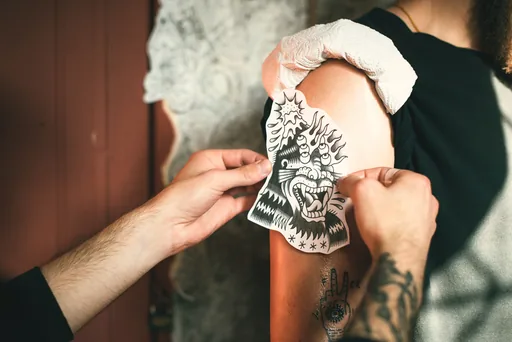 A stencil being placed on a client’s arm