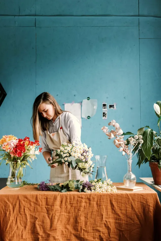 A florist arranging a bouquet in her studio
